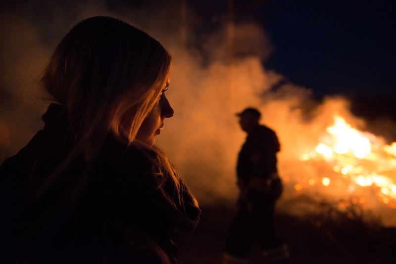 Are You Burning Up? Join Us To Discuss Into The Fire - Young woman looking at fire with man standing in the background