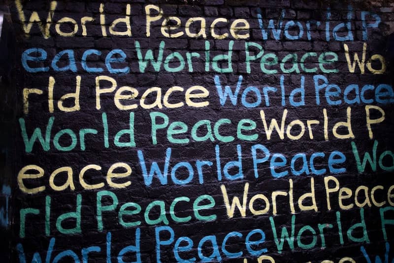 Image - The words "world peace" written multiple times in chalk - Exploring Green Politics And The Peace Pillar